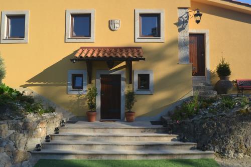a yellow house with stairs in front of it at CASA DO SORRO in Ponte de Lima