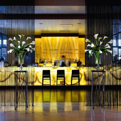 a lobby with two chairs and a table with flowers at Best Western Premier BHR Treviso Hotel in Quinto di Treviso