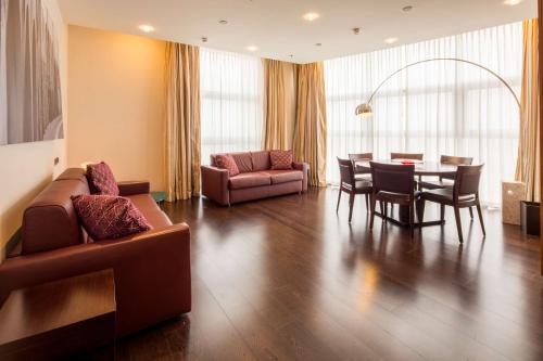 a living room with a couch and a table and chairs at Best Western Premier BHR Treviso Hotel in Quinto di Treviso