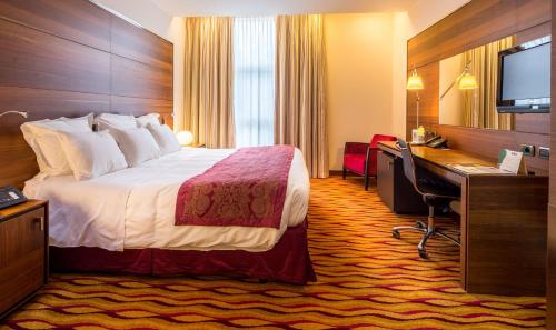 a hotel room with a bed and a desk at Best Western Premier BHR Treviso Hotel in Quinto di Treviso