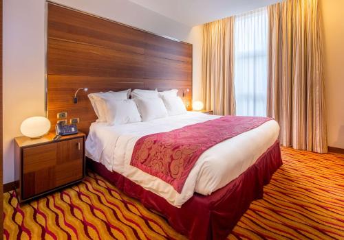 a hotel room with a large bed and a large window at Best Western Premier BHR Treviso Hotel in Quinto di Treviso