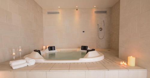 a bath tub in a bathroom with a shower at Best Western Premier BHR Treviso Hotel in Quinto di Treviso