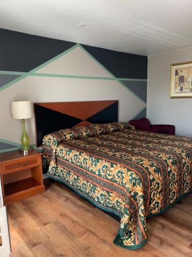 1 dormitorio con 1 cama con pared a rayas en Royal Inn & Suites, en Knoxville