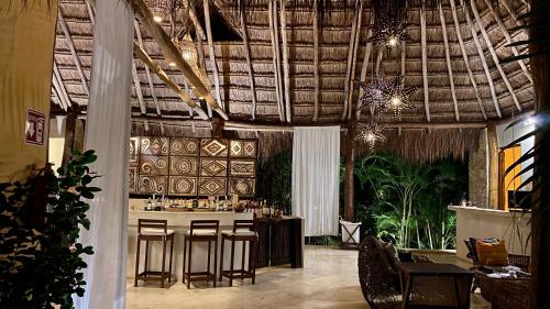 a bar with stools in a room with a ceiling at Piedra de Agua Palenque in Palenque