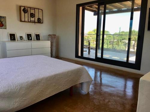 a bedroom with a bed and a large window at Daniela in Sant Francesc Xavier