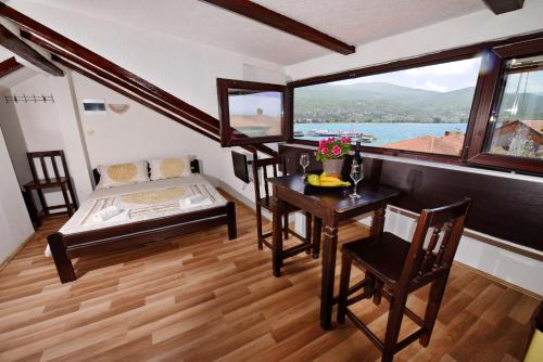a room with a table and a bed and a window at Villa Sapkar Lake View in Ohrid