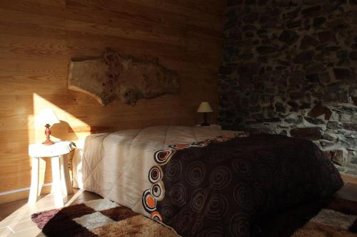 a bedroom with a bed and a table with a lamp at Casa do Moinho Novo I in Fontão Fundeiro