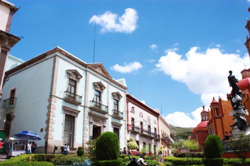 a group of buildings on a street with a blue sky at Hotel de la Paz in Guanajuato