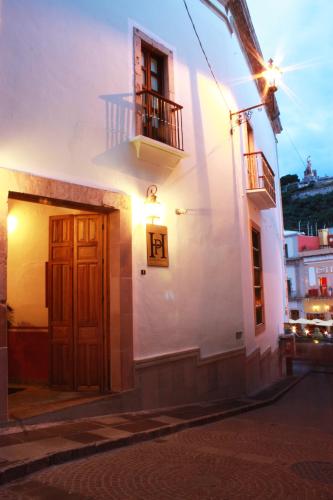 a white building with a door and a balcony at Hotel de la Paz in Guanajuato