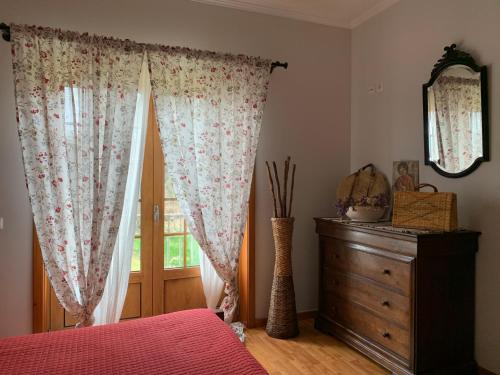 a bedroom with a bed and a dresser and a window at Quinta das Ameixas - Country & Nature in Arouca