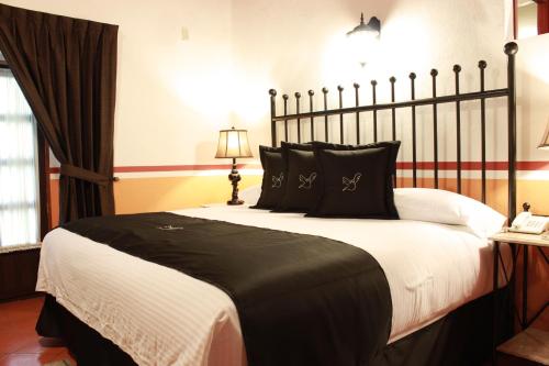 a bedroom with a large black and white bed at Hotel de la Paz in Guanajuato