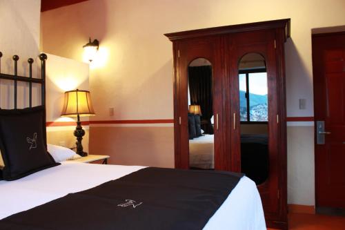 a hotel room with a bed and a mirror at Hotel de la Paz in Guanajuato