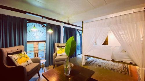 a bedroom with a bed and a table and a room with a window at Twelve Cutting Units in Sukhothai