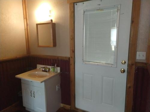baño con lavabo y puerta blanca en La Loma del Chivo Llc - The Spirit room en Marathon