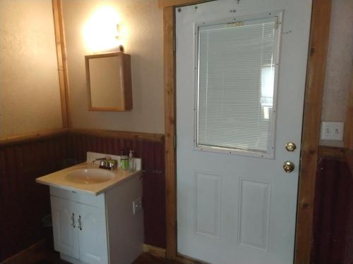 a bathroom with a sink and a white door at La Loma del Chivo Llc - The Spirit room in Marathon
