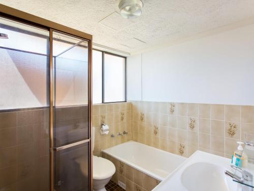 uma casa de banho com um WC, um lavatório e um chuveiro em Champagne Court 1 em Tuncurry