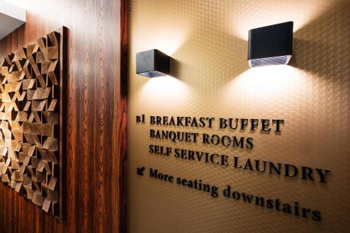a bathroom with two lights and a sign on the wall at LALA VIANCO BUSINESS Hotel in Busan