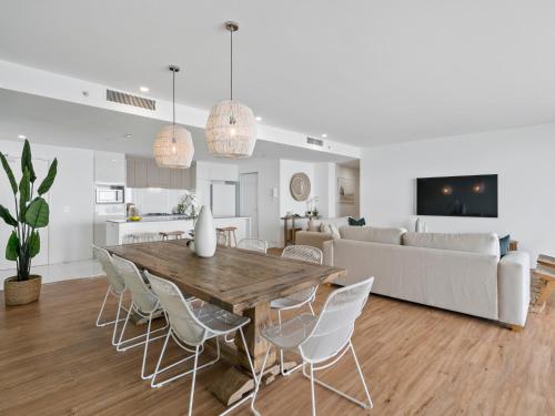 a dining room and living room with a wooden table and chairs at Circle on Cavill - Gclr in Gold Coast