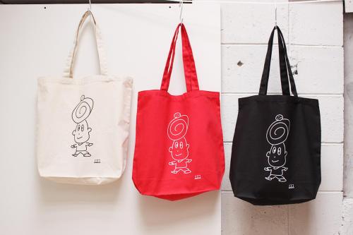 three bags are hanging on a wall at コトのアート研究所 in Ishinomaki
