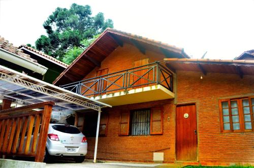 um carro estacionado em frente a uma casa com varanda em Casa Luz Serrana em Monte Verde