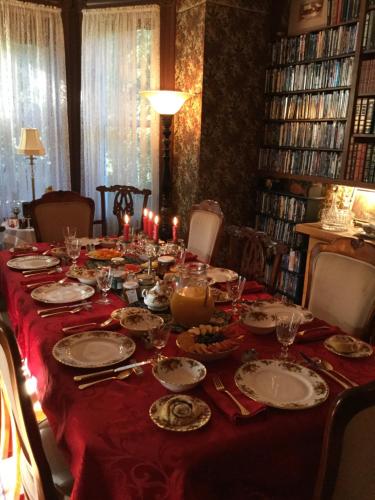 une longue table avec un chiffon de table rouge et des bougies dans l'établissement Pemberley House Bed and Breakfast, à Seaforth