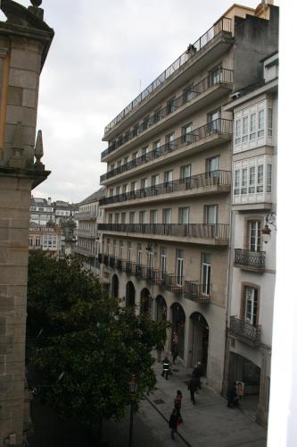 a large building with people walking in front of it at Hotel Mendez Nuñez in Lugo