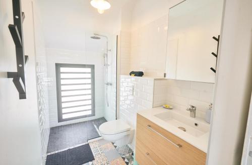 uma casa de banho branca com um WC e um lavatório em Villa Standing avec piscine, jardin, bord de mer em Saint-Gilles-les-Bains