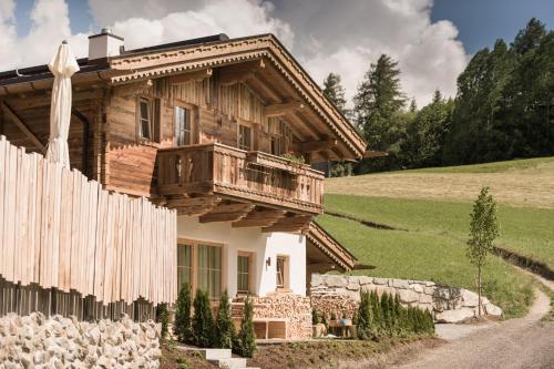 a wooden house with a balcony and a fence at Hüttendorf Ladizium in Ladis