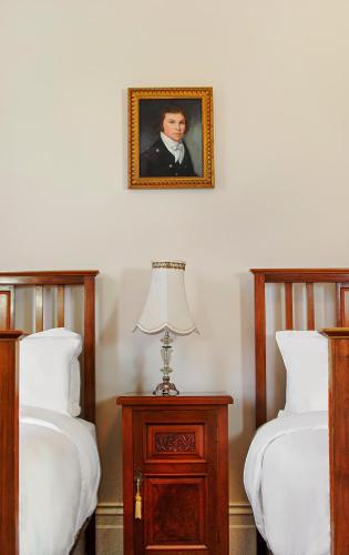 a picture of a man on the wall above two beds at Langsford Luxury in Stawell