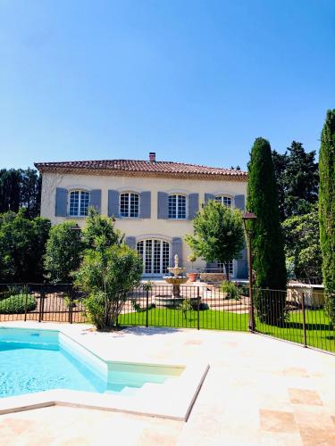 une grande maison avec une piscine en face de celle-ci dans l'établissement Villa Agrippa, à Orange