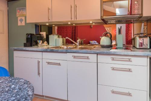 a kitchen with white cabinets and a sink at Loveroom in Interlaken