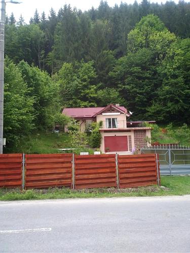 a house behind a wooden fence on the side of the road at Casa Ozon in Vulcan