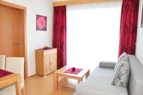 a living room with a couch and a large window at Pension Waldheim in Mauterndorf