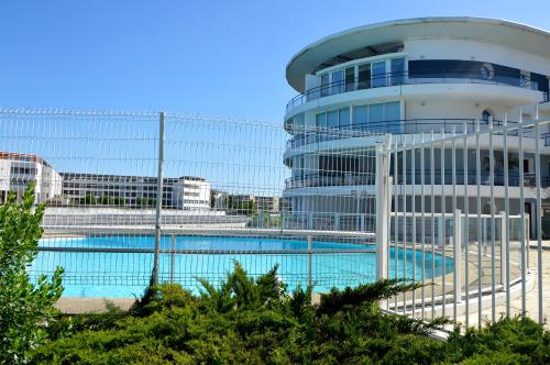 un bâtiment avec une piscine devant dans l'établissement OSoleMio La Rochelle, à La Rochelle