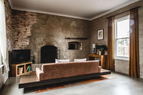 a living room with a couch and a fireplace at Ravenswood Homestead in Ravenswood