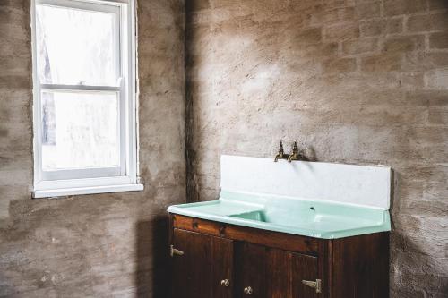 a bathroom with a sink and a window at Ravenswood Homestead in Ravenswood
