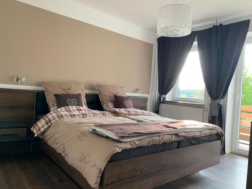 a bedroom with a large bed and a window at Harzstübl25 in Sankt Andreasberg