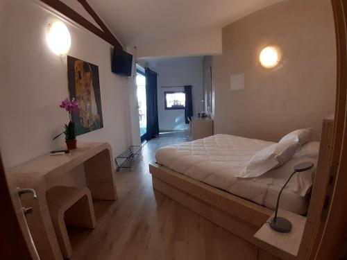 una camera con letto e tavolo con lampada di Locanda Sapori a Sanremo