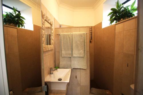 bagno con lavandino, servizi igienici e 2 piante di Studio 10 A a Faro