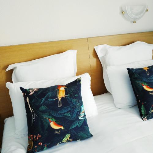 a bed with two pillows on it with at Brit Hotel Hermitage in Royan