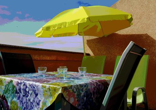 einen Tisch mit gelbem Regenschirm und Gläsern darauf in der Unterkunft Apartman Mery Stinjan in Pula