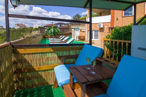 a patio with a wooden table and chairs on a balcony at Sea view apartments in Odesa