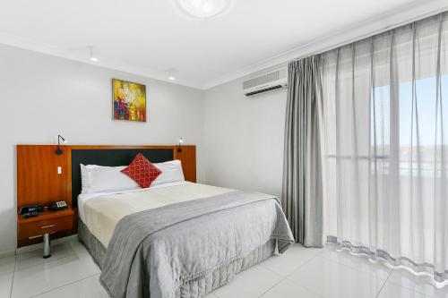 a bedroom with a bed and a large window at Comfort Inn & Suites Burwood in Sydney