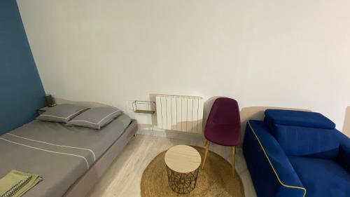 1 dormitorio con 1 cama, 1 sofá y 1 silla en Studio aux Sources de la Chabanne, en Saint-Hilaire-les-Courbes