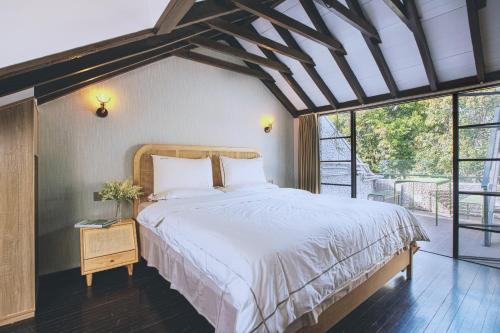 a bedroom with a large bed and a window at Shanghai Downtown Hills Boutique Guesthouse - Near Metro Line 7, Exit 3, Changping Road in Shanghai