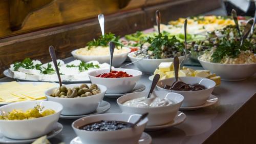 a table topped with bowls of different types of food at Nartorama HotRest in Zieleniec