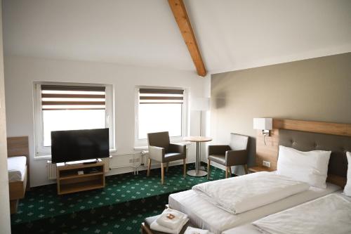 ein Hotelzimmer mit einem Bett und einem Flachbild-TV in der Unterkunft Hotel Novostar in Göttingen
