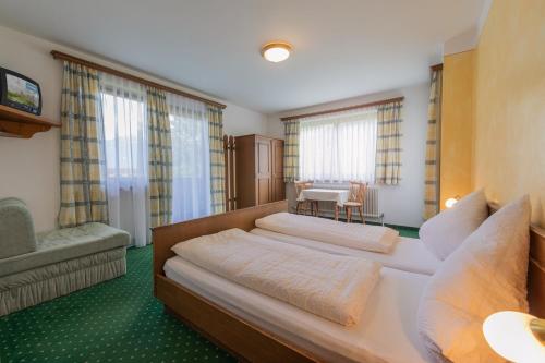 a hotel room with two beds and a table at Gästehaus Danler in Neustift im Stubaital