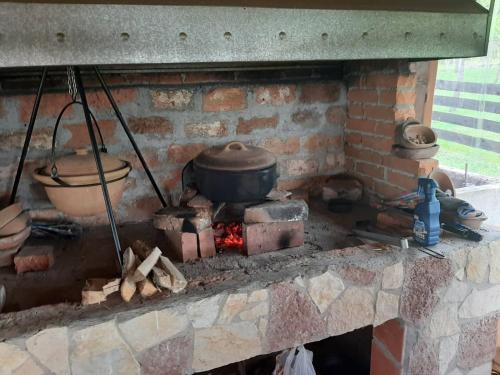 a brick fireplace with pots and pans on it at Seosko domaćinstvo Bondžulić in Užice