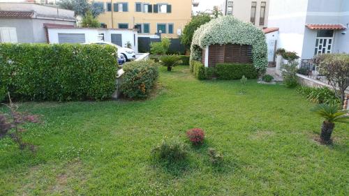 a yard with a green lawn with a hedge and a building at Impero 6 in Scauri